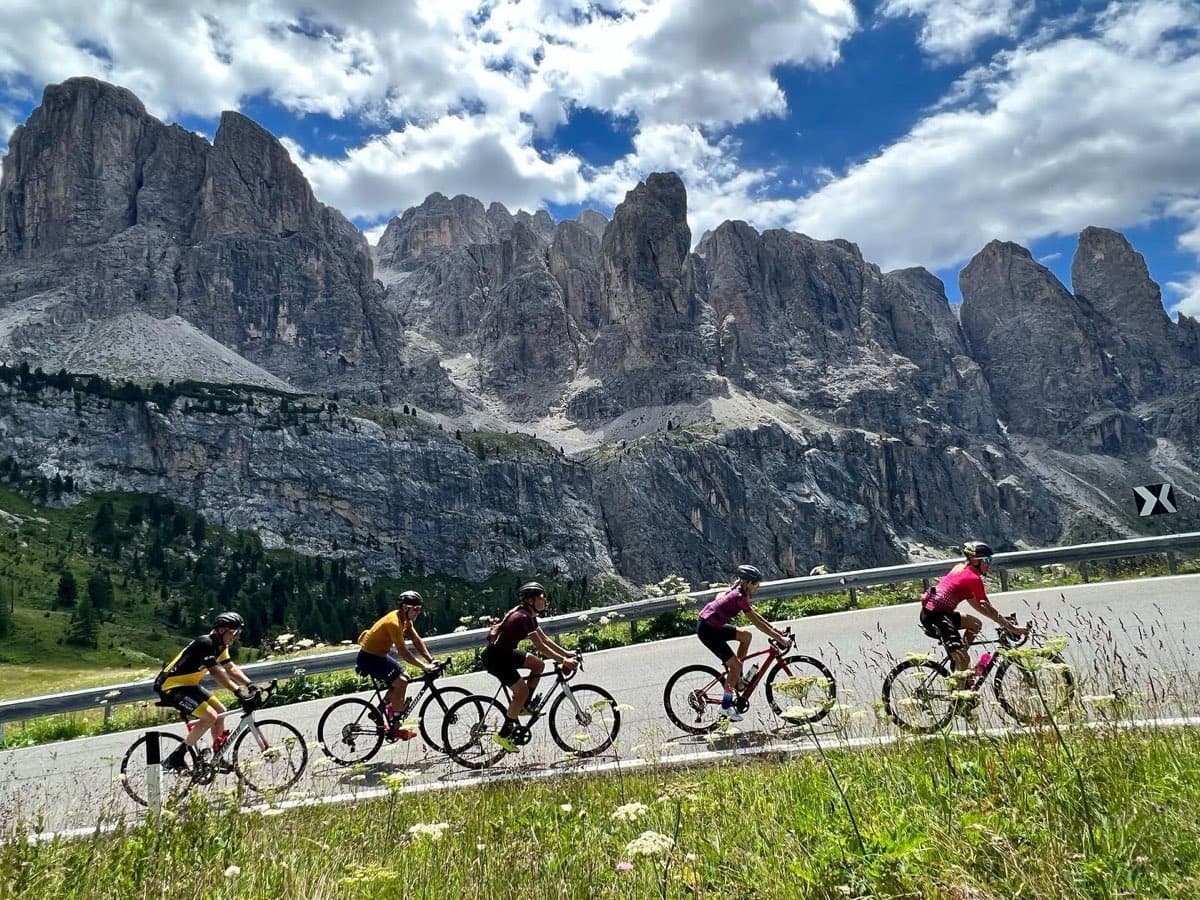 A road peloton climbing beneath limestone spires