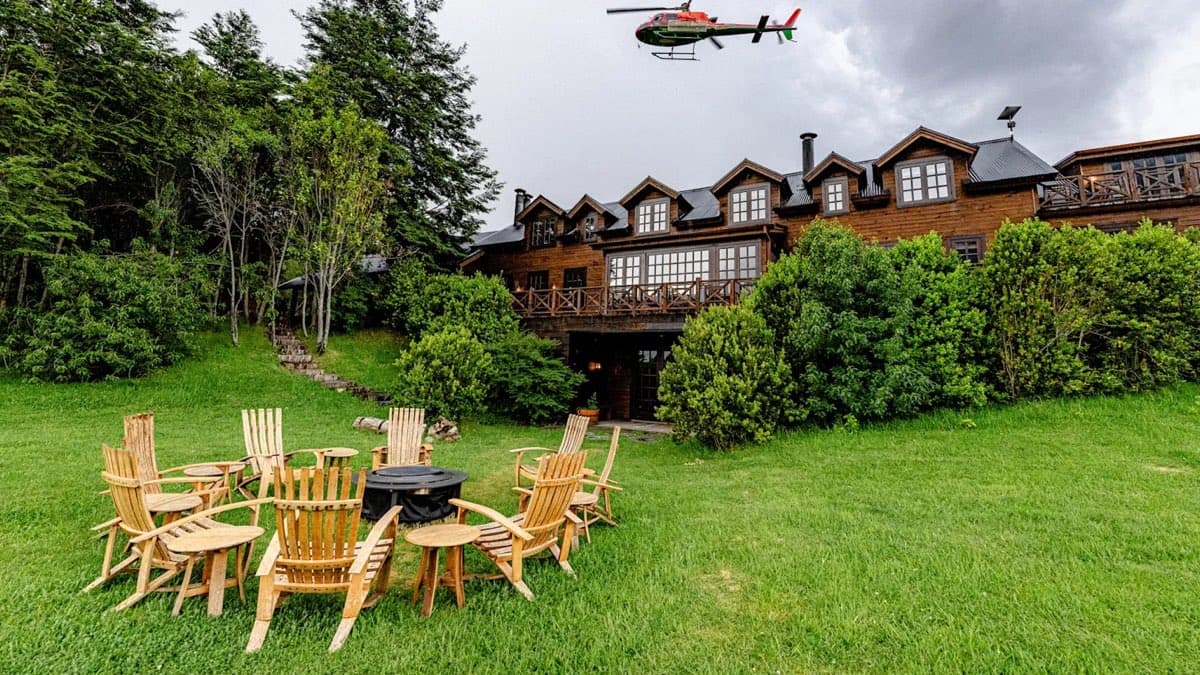 A timber adventure lodge above a lawn of Adirondack chairs
