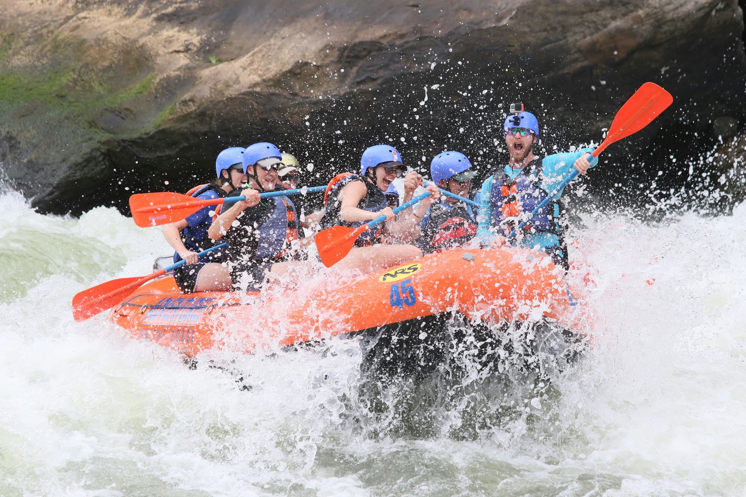 A guided raft crew paddling hard through whitewater.